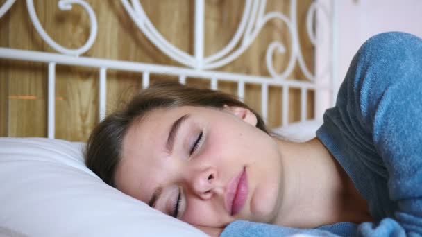 若い女性のベッドでカメラ目線の笑顔をクローズ アップ — ストック動画