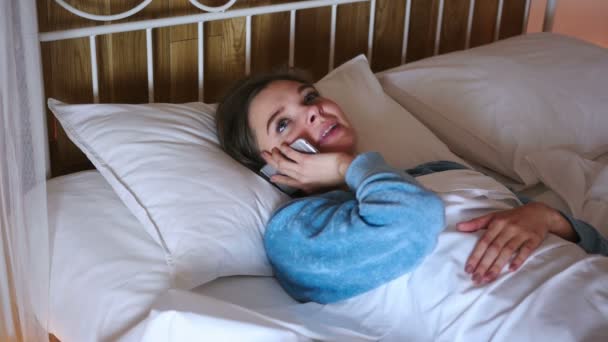 Frau im Bett wählt Anruf und telefoniert — Stockvideo