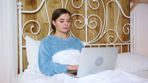 Frau im Bett schockiert über Ergebnisse auf Laptop — Stockvideo