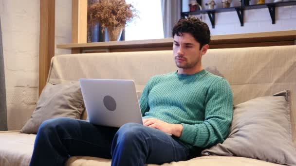 Homem completando o trabalho no laptop e deixando a sala de estar — Vídeo de Stock