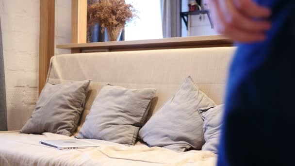 Odpočiňte si člověka, jak přichází na obývací pokoj a pracovat na notebooku — Stock video