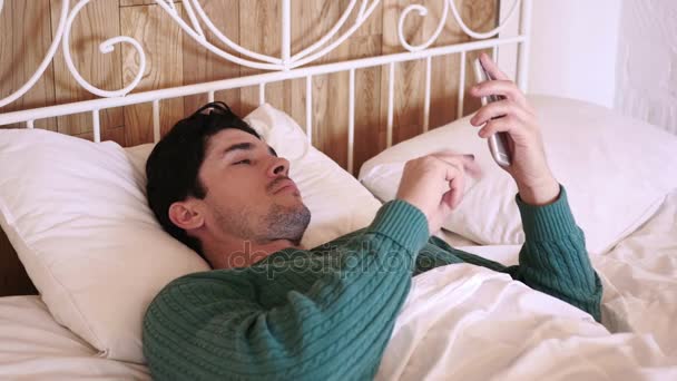 Mann im Bett surft nachts auf Smartphone — Stockvideo