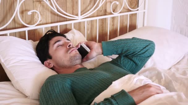 Mannen i sängen uppringning samtal och talande på telefon — Stockvideo