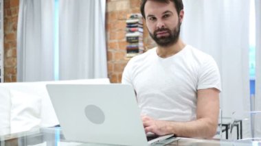Evde ciddi genç sakallı adam modelinin yakın çekim