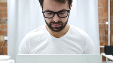 Yorgun sakallı adam çalışırken dizüstü bilgisayarda çalışırken Relax,