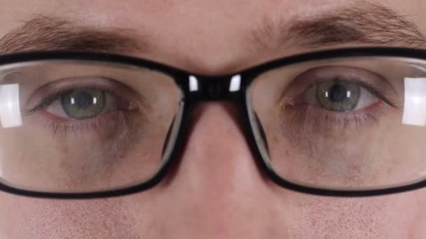 Primer plano de los ojos guapos parpadeantes del hombre en gafas — Vídeo de stock