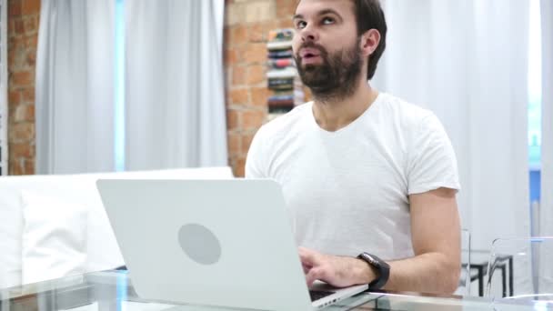 Junger Mann mit Bart wartet bei der Arbeit und beobachtet die Zeit auf der Wache — Stockvideo