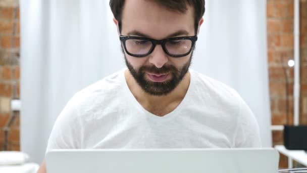 Retrato de sonriente barba positiva hombre trabajando en el ordenador portátil — Vídeos de Stock