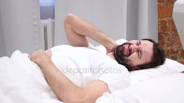 Vousy muž s bolesti krční páteře, snaží se odpočívat v posteli — Stock video