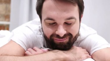 Yatakta yatarken, kabul için başını sallayarak genç sakallı adam tarafından Evet