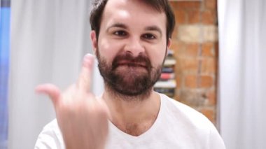 Orta parmak öfkeyle gösterilen ciddi sakallı adam