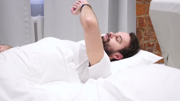 Unruhige ma wartend und die Zeit beobachtend, liegend im Bett — Stockvideo