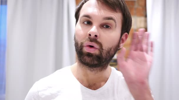 Junger schöner Mann mit Bart hört heimlich zu, drinnen — Stockvideo
