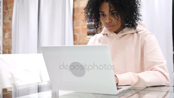 Mulher afro-americana excitada comemorando o sucesso enquanto trabalhava no laptop, sentada no sofá — Vídeo de Stock