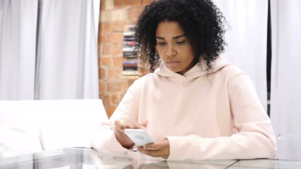 Afroamerikanerin am Arbeitsplatz surft im Büro mit Smartphone — Stockvideo