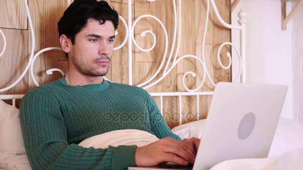 L'homme qui se demande au lit, choc par les résultats sur ordinateur portable — Video