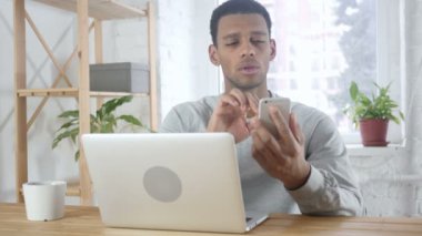 Smartphone üzerinde tarama, tipik haber genç Afro-Amerikan adam