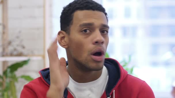 Jeune bel homme afro-américain écoutant secret, fond blanc — Video