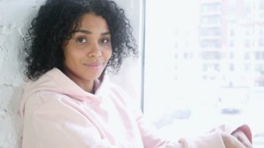 Kabul etmek için Evet, pencerede oturup başını sallayarak genç Afrikalı kadın