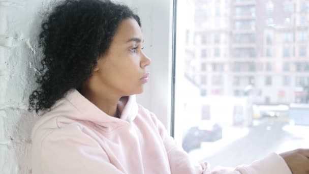 Close-up da jovem mulher afro-americana, olhando através da janela — Vídeo de Stock