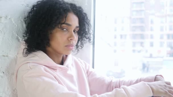 Fiatal afrikai nő mutatott a kamera ül az ablakban — Stock videók