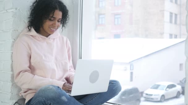 Online Video Chat από αφρο-αμερικανικό γυναίκα, κάθεται στο παράθυρο — Αρχείο Βίντεο