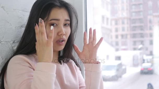 Молоді азіатські жінки кричати і збирається з розуму, сидячи у вікні програми — стокове відео