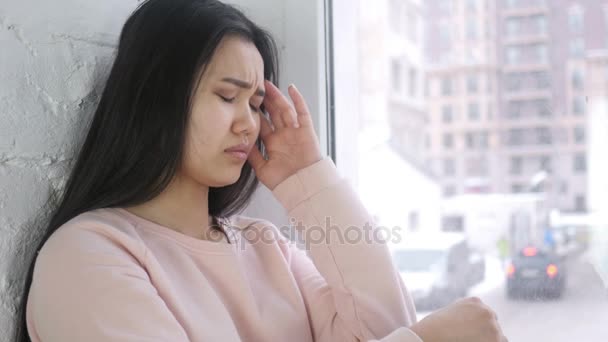 Ból głowy, sfrustrowany młody Asian kobieta siedzi w okienku — Wideo stockowe