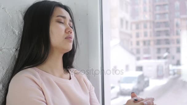 Mladá asijská žena spí, sedí u okna — Stock video