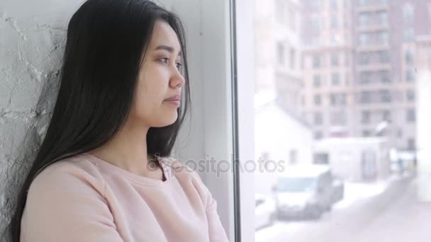 Joven mujer asiática bostezando, sentada en la ventana — Vídeo de stock