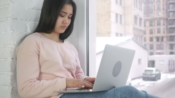 Σοκαρισμένος, αναρωτιέστε σε γυναίκα που εργάζεται σε φορητό υπολογιστή, κάθεται στο παράθυρο — Αρχείο Βίντεο