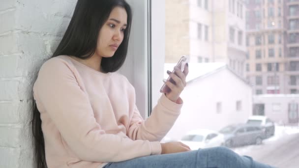 Jeune femme asiatique Regarder sur Smartphone à choc, se demandant — Video