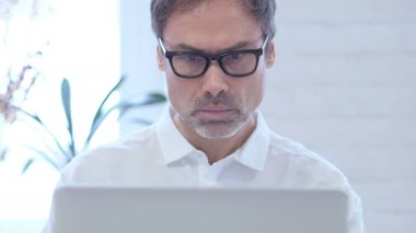 Kızgın orta yaşlı adamın üstünde Laptop ofiste çalışan yakın çekim