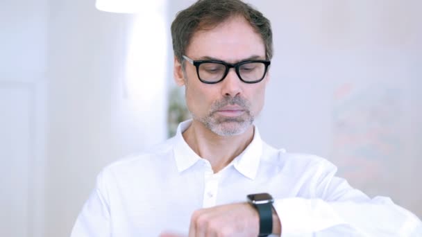 Uomo di mezza età utilizzando Smartwatch, Navigando online sul lavoro — Video Stock