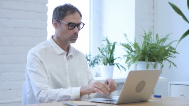Zamyšlený středního věku člověk myslí a pracuje na Laptop — Stock video