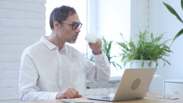 Relaxant Moyen Age Homme Boire du café tout en étant assis au bureau — Video