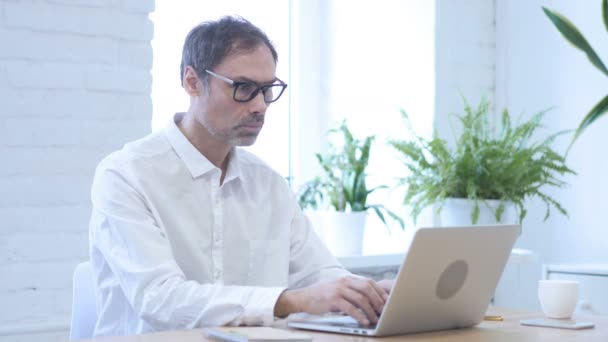 Hombre en shock, preguntándose mientras trabaja en el ordenador portátil — Vídeo de stock