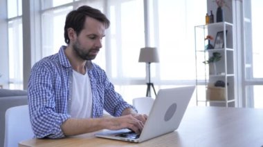 Laptop ofis, yakın çalışan rahat sakallı adam