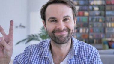 Ofiste rahat sakallı adam zafer işareti