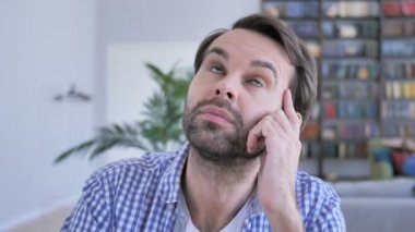 Düşünme ve dizüstü bilgisayarda çalışan dalgın rahat sakallı adam