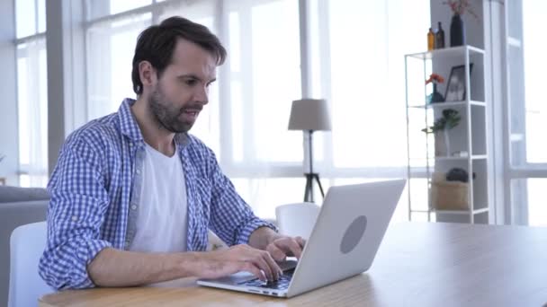 Homem de barba casual animado comemorando o sucesso, trabalhando no laptop — Vídeo de Stock