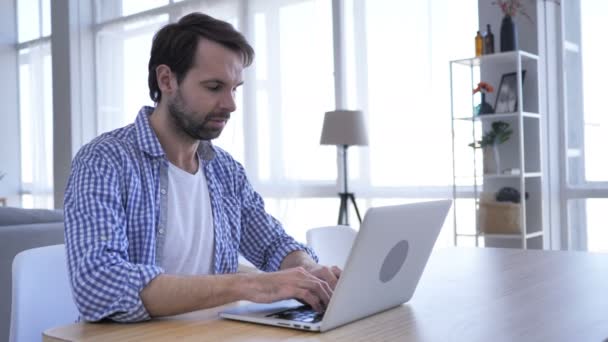 Homme à barbe occasionnel travaillant sur ordinateur portable dans le bureau, Gros plan — Video