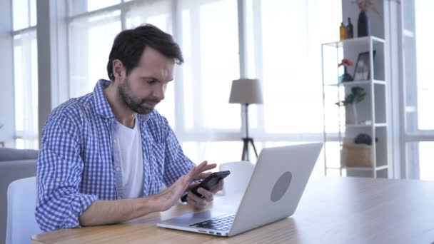 Mann mit lässigem Bart surft auf Smartphone im Internet — Stockvideo