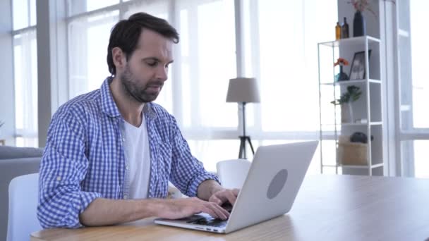 Sí, el hombre de la barba casual acepta la oferta sacudiendo la cabeza mientras trabaja en el ordenador portátil — Vídeos de Stock