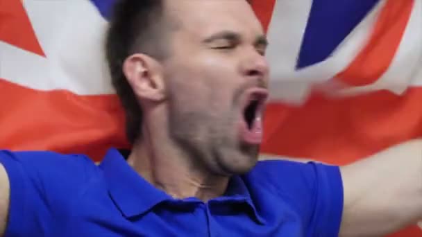 Britský fanoušek slaví podržíte britské vlajky v pomalém pohybu — Stock video