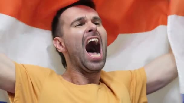 Netherlands fan celebrating while holding the flag of Netherlands in Slow Motion — Stock Video