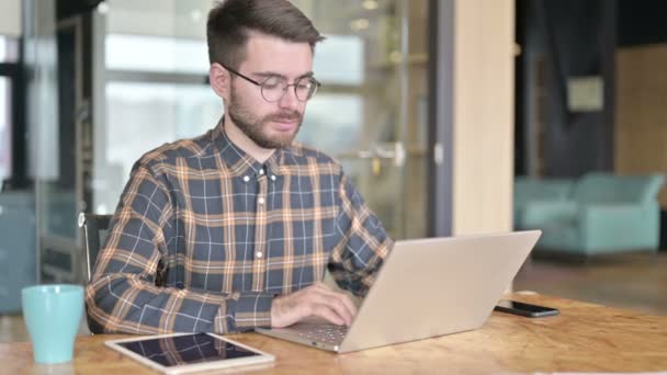 Jovem Designer usando laptop no escritório moderno — Vídeo de Stock