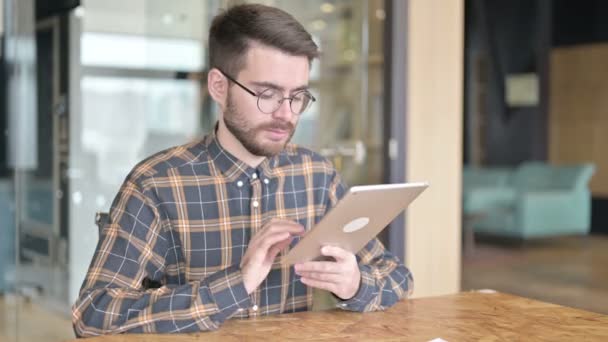 Εργατικός νεαρός σχεδιαστής Χρησιμοποιώντας Tablet στο σύγχρονο γραφείο — Αρχείο Βίντεο