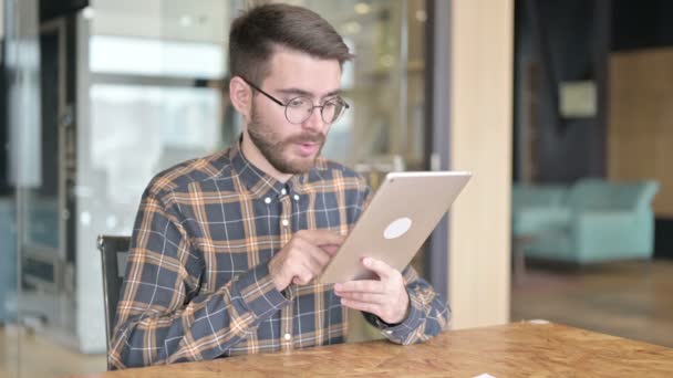 Fleißiger Jungdesigner mit Erfolg auf Tablet im Büro — Stockvideo