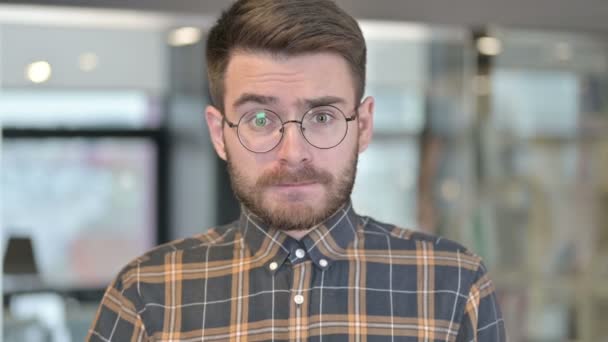 Πορτρέτο του σοκ νεαρός σχεδιαστής αντιδρώντας στην απώλεια στο γραφείο — Αρχείο Βίντεο